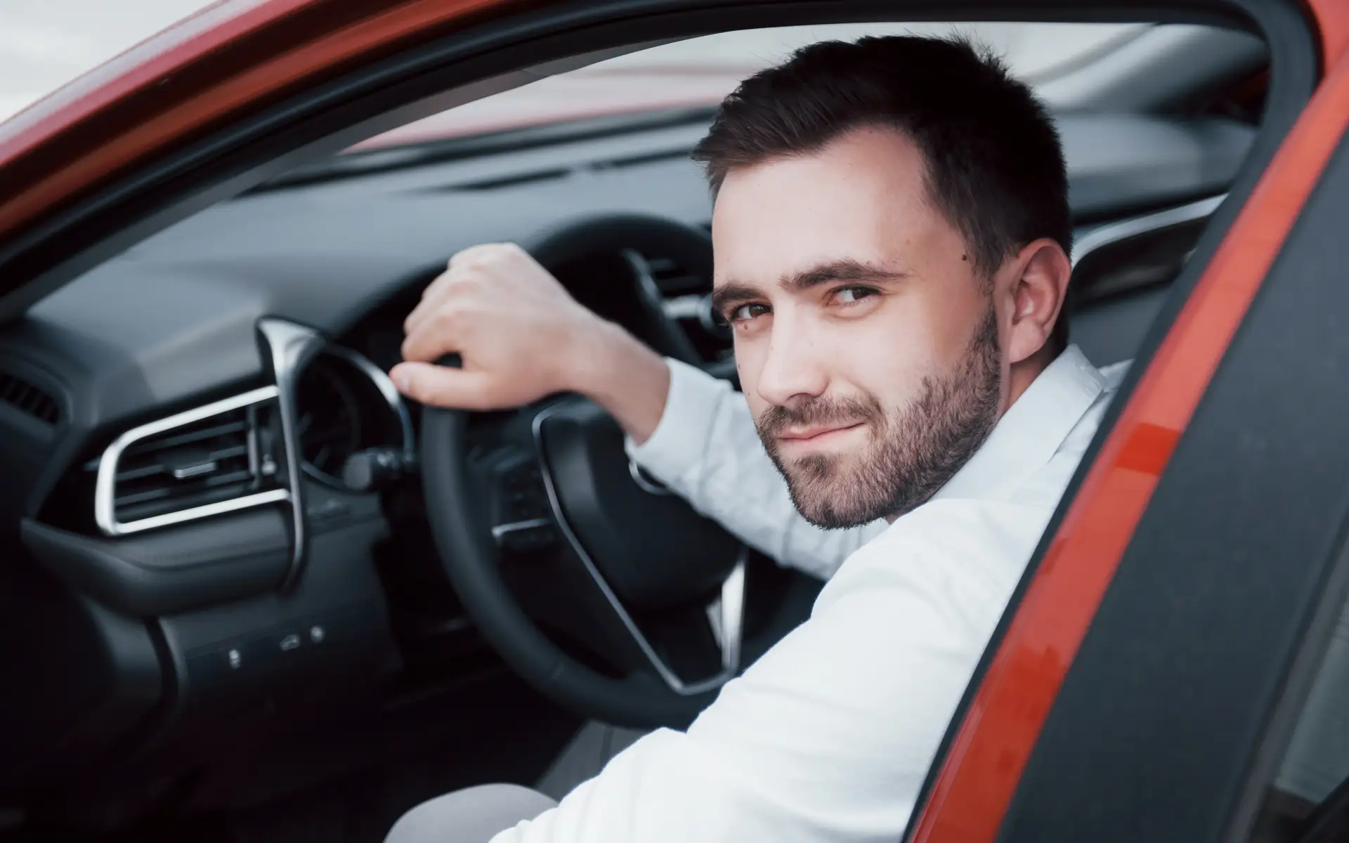 Man sitting in car smiling